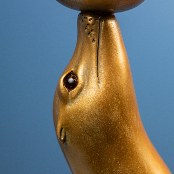 Detail Kopf, goldene Robbe balanziert Glaskugel auf der Schnauze
